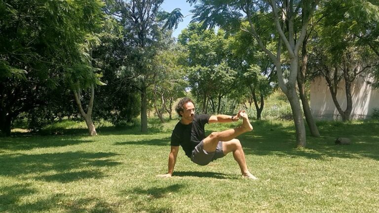 Persona haciendo crab toe touches, un ejercicio de equilibrio en el parque.