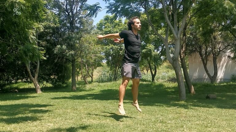 Persona haciendo jumping squats y saltando en un parque verde.